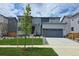 Contemporary two-story home with a manicured lawn, a driveway, and a two-car garage at 2560 Lupton Ln, Lafayette, CO 80026