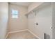 Bright laundry room with a window, tiled floor, shelf, and utility connections at 2560 Lupton Ln, Lafayette, CO 80026