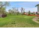 Spacious backyard with lush green grass, mature trees, and wooden fence around the perimeter at 3970 Pierson St, Wheat Ridge, CO 80033