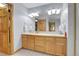Well-lit bathroom with dual sinks, wooden cabinets and large mirror offering ample counter space at 3970 Pierson St, Wheat Ridge, CO 80033