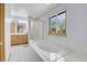 Bright bathroom showcasing a soaking tub, shower, and vanity with light wood cabinets at 3970 Pierson St, Wheat Ridge, CO 80033