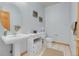 Bathroom with pedestal sink, toilet, and tile floors at 3970 Pierson St, Wheat Ridge, CO 80033