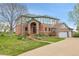 Two-story brick home with landscaped front yard, driveway, and attached garage at 3970 Pierson St, Wheat Ridge, CO 80033