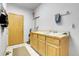 Functional laundry room features tiled floor, storage cabinets, and sink with cleaning supplies at 3970 Pierson St, Wheat Ridge, CO 80033