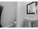 Modern powder room with pedestal sink, decorative tile floor, and minimalist decor at 6456 Kenzie Cir, Castle Pines, CO 80108