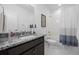 Bathroom with a granite vanity, white subway tile shower, and modern fixtures at 6456 Kenzie Cir, Castle Pines, CO 80108