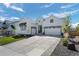 Attractive white home with a large driveway and two-car garage at 6456 Kenzie Cir, Castle Pines, CO 80108