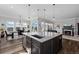 Bright kitchen with a large granite island, stainless steel appliances, pendant lighting, and an eat-in dining area at 6456 Kenzie Cir, Castle Pines, CO 80108