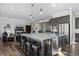 Open kitchen featuring a large island with seating, granite countertops, stainless appliances, and a cozy living space at 6456 Kenzie Cir, Castle Pines, CO 80108