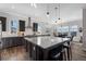 Modern kitchen with dark cabinets, a large island, and pendant lighting at 6456 Kenzie Cir, Castle Pines, CO 80108