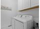 Functional laundry area with modern side-by-side white washer and dryer units at 6456 Kenzie Cir, Castle Pines, CO 80108