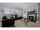 Cozy living room featuring a fireplace, large windows, and comfortable seating at 6456 Kenzie Cir, Castle Pines, CO 80108