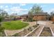 Expansive backyard features a patio, garden beds, mature trees, and a lush lawn at 2588 S Flower Ct, Lakewood, CO 80227