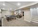 This large basement features a ping pong table, entertainment space, and stairs to the upper level at 2588 S Flower Ct, Lakewood, CO 80227