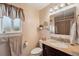 This bathroom features granite countertops, a tiled shower, and a window for natural lighting at 2588 S Flower Ct, Lakewood, CO 80227