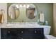 Bathroom boasts dual sinks, black cabinets, and a modern lighting fixture at 2588 S Flower Ct, Lakewood, CO 80227