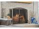Close up of a brick fireplace with an iron screen, wood logs, and a decorative vase at 2588 S Flower Ct, Lakewood, CO 80227