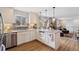 Bright kitchen with white cabinets, granite countertops, stainless steel appliances, and a view to the living room at 2588 S Flower Ct, Lakewood, CO 80227