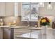 Modern kitchen sink with granite countertops, white cabinets, tile backsplash and a kitchen aid mixer at 2588 S Flower Ct, Lakewood, CO 80227
