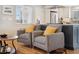 Bright and inviting living area with neutral-toned chairs, hardwood floors, and an open view to the kitchen at 2588 S Flower Ct, Lakewood, CO 80227