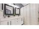 Stylish bathroom featuring double sinks, modern fixtures, and a shower with a textured curtain at 13464 Vine St, Thornton, CO 80241