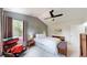 Bright bedroom with a ceiling fan, large window, and sitting area with comfortable leather chair at 13464 Vine St, Thornton, CO 80241