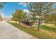 Exterior view of home with mature trees, landscaped yard and a community sidewalk at 1941 Newland Ct, Lakewood, CO 80214