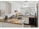 Kitchen with plenty of counter space, black appliances, and white cabinets at 1941 Newland Ct, Lakewood, CO 80214