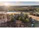 Stunning aerial view of a luxurious home surrounded by lush greenery and a serene pond, offering a picturesque setting at 1052 Country Club Estates Dr, Castle Rock, CO 80108