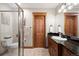 Bright bathroom features a glass shower, wood door and accents, granite counters, and a vessel sink at 1052 Country Club Estates Dr, Castle Rock, CO 80108