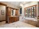 Bright bathroom features a jacuzzi tub situated under a large window at 1052 Country Club Estates Dr, Castle Rock, CO 80108