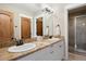Bathroom featuring a double vanity with granite counters and a separate glass enclosed shower at 1052 Country Club Estates Dr, Castle Rock, CO 80108