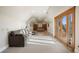 A bright bonus room has a comfortable couch, a desk with built in shelving, and a sun drenched balcony at 1052 Country Club Estates Dr, Castle Rock, CO 80108