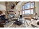 Inviting living room with a stone fireplace, plush seating, and a large window showcasing breathtaking mountain views at 1052 Country Club Estates Dr, Castle Rock, CO 80108