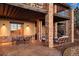 Covered patio with stone columns, dining, and seating areas at 1052 Country Club Estates Dr, Castle Rock, CO 80108