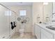 Bright bathroom with white vanity, shower with glass doors, decorative wall art, and neutral tile flooring at 22323 E 6Th Pl, Aurora, CO 80018