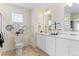 Bathroom featuring dual sinks, white cabinets and decorative artwork at 22323 E 6Th Pl, Aurora, CO 80018