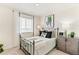 Cozy bedroom featuring a metal frame bed, unique artwork, neutral walls, and ample natural light at 22323 E 6Th Pl, Aurora, CO 80018