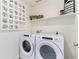 Functional laundry room with modern white front-load washer and dryer at 22323 E 6Th Pl, Aurora, CO 80018