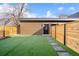 The backyard features a modern-style fence and new, artificial turf, creating a tidy outdoor space at 19 Washington Ave, Golden, CO 80403