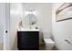 Stylish half bathroom with a black vanity, round mirror, and gold accents at 19 Washington Ave, Golden, CO 80403