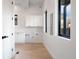 Clean laundry room with white cabinets, light hardwood floors, and modern fixtures at 19 Washington Ave, Golden, CO 80403