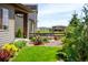 Backyard features a stone patio with seating, lush landscaping, and a view at 6530 Barnstead Dr, Castle Pines, CO 80108