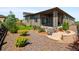 Backyard with a stone patio seating area surrounded by lush landscaping at 6530 Barnstead Dr, Castle Pines, CO 80108
