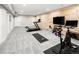 Bright exercise room with wood accent wall, treadmill, weights, and stationary bike at 6530 Barnstead Dr, Castle Pines, CO 80108