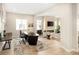Bright home office with large desk, comfortable seating, and a view into a cozy living room with a fireplace at 6530 Barnstead Dr, Castle Pines, CO 80108