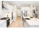 Bright kitchen with white cabinetry, stainless steel appliances, and a sleek island with quartz countertops at 6530 Barnstead Dr, Castle Pines, CO 80108