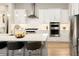 This gourmet kitchen features white cabinetry, stainless steel appliances, and a large island with seating at 6530 Barnstead Dr, Castle Pines, CO 80108