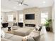 Bright living room featuring a stacked stone fireplace, large sectional sofa and a modern ceiling fan at 6530 Barnstead Dr, Castle Pines, CO 80108
