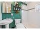 Stylish bathroom with green walls, subway tile shower, floating shelves, and modern fixtures at 3640 N Saint Paul St, Denver, CO 80205